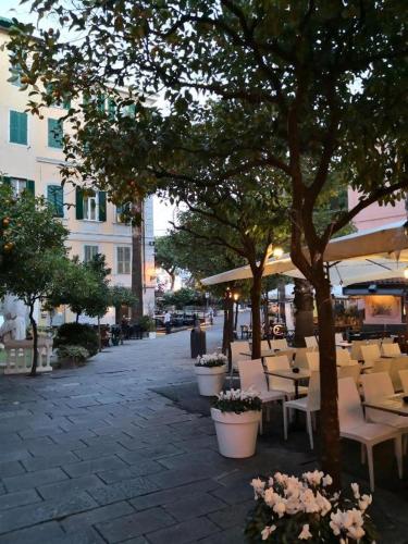 a street with tables and chairs and trees at Petit avec classe Sanremo in Sanremo