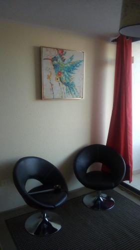 two black chairs sitting in a room with a window at Atacama Valley 5 in Copiapó