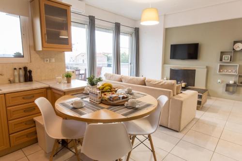 a kitchen and living room with a table and a couch at Nathaniel Athens Airport in Spata