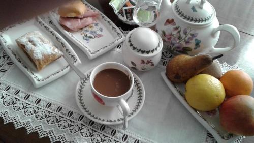 a table with a cup of tea and a tray of food at Petit avec classe Sanremo in Sanremo