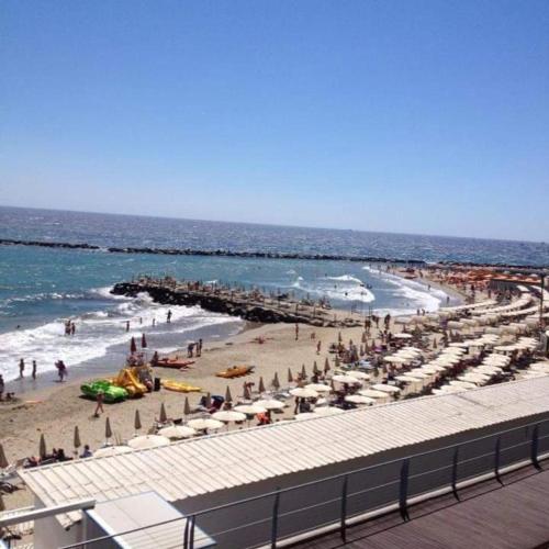 a beach with umbrellas and people on the beach at Petit avec classe Sanremo in Sanremo