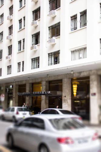 a white building with cars parked in front of it at HOTEL DEL REY CURITIBA by POTY - NA FAMOSA RUA XV DE NOVEMBRO in Curitiba