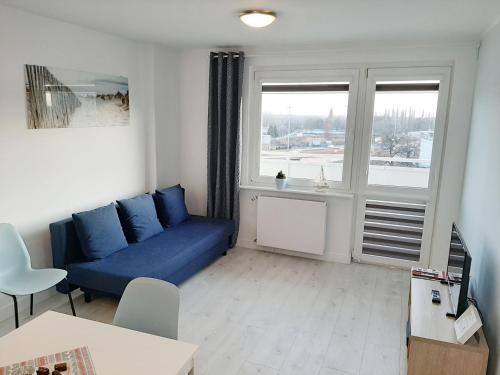 a living room with a blue couch and a window at Apartment near Old Town - Długie Ogrody in Gdańsk