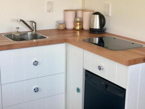 a kitchen with white cabinets and a sink at Mitchella farm in Wanaka