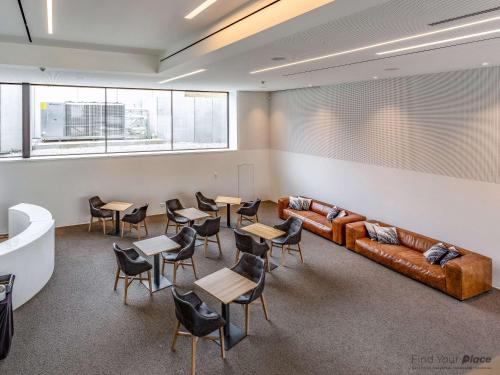 a waiting room with a couch and tables and chairs at Golden Lakes Hotel in Boussu-lez-Walcourt