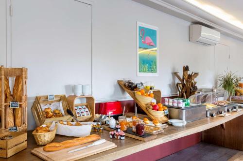 a buffet with bread and other food on a counter at Best Western Plus Hyères Côte D'Azur in Hyères