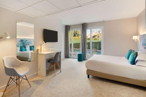 a bedroom with a bed and a desk and a television at Best Western Plus Hyères Côte D'Azur in Hyères