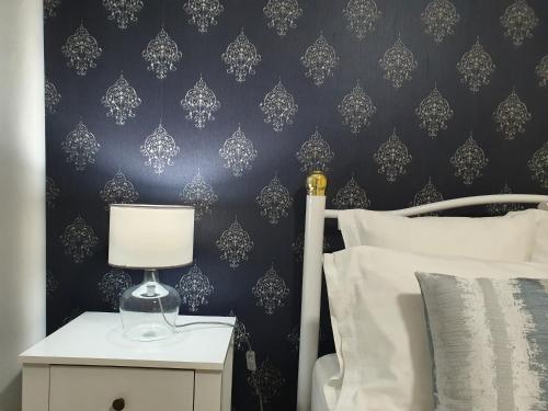 a bedroom with a bed and a nightstand with a lamp at kelly's House Plateau City Center in Praia