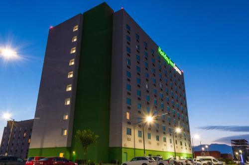un edificio con un cartello verde di Holiday Inn Express Saltillo Zona Aeropuerto by IHG a Saltillo