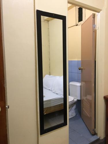 um espelho na casa de banho com uma cama e um WC em Querencia Inn em Banaue