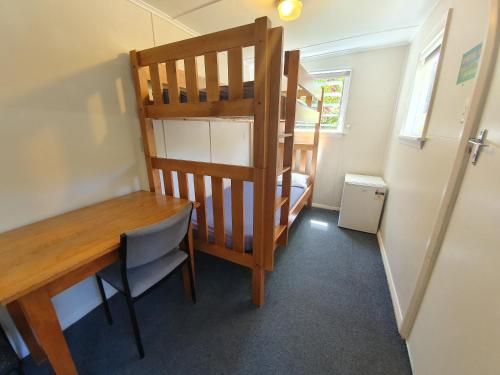 プナカイキにあるPunakaiki Beach Campのデスク、二段ベッドが備わる小さな客室です。