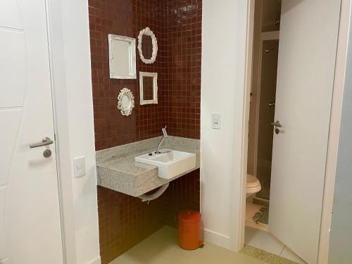 a bathroom with a sink and a toilet at Arraial do Cabo-Apartamento para temporada-Condomínio Golden Lake in Arraial do Cabo
