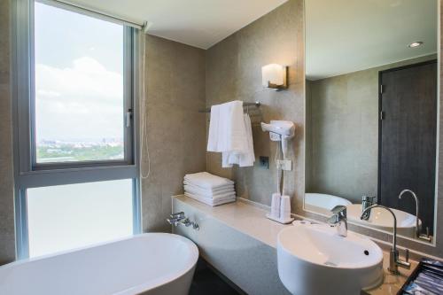 a bathroom with a sink and a toilet and a window at Jin Shi Hu Hotel in Kaohsiung