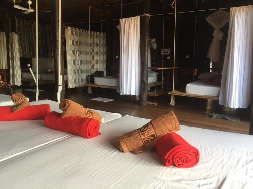 Una cama con almohadas rojas y marrones. en ST 63 Home Stay & Tour Kampong Khleang en Kâmpóng Khleăng