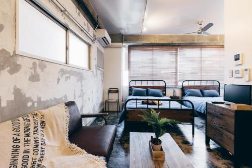 大阪市にあるPack Studio Tanakaの二段ベッド2台とソファのある部屋
