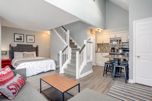 a bedroom with a bed and a kitchen with a staircase at Blue Mountain Studio Loft at North Creek Resort in Blue Mountains