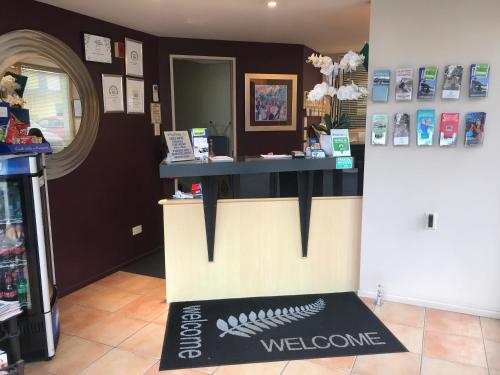 a counter in a store with a welcome mat on the floor at Harbour City Motor Inn & Conference in Tauranga