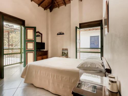 a bedroom with a white bed and a window at Balcones del Parque Jardin in Jardin