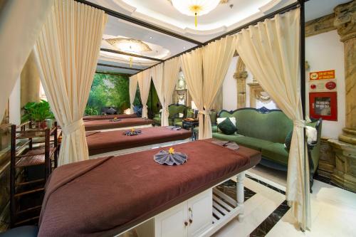 a bedroom with two beds and a green couch at Hanoi Media Hotel & Spa in Hanoi