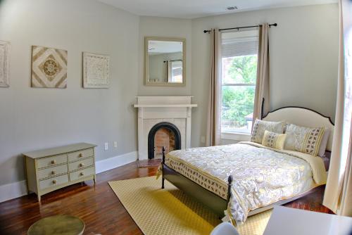 1 dormitorio con cama, chimenea y espejo en 2 Bedroom Newly Renovated Townhome in Historic Savannah en Savannah