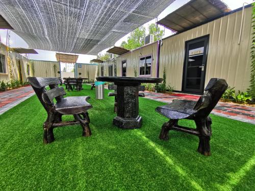 two chairs and a table in a yard with grass at TT Dorf Hotel Matang in Taiping