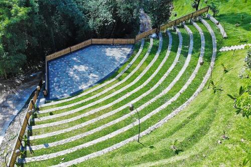 an empty amphitheater with a pool in the grass at Shanaya Resort Malang in Malang