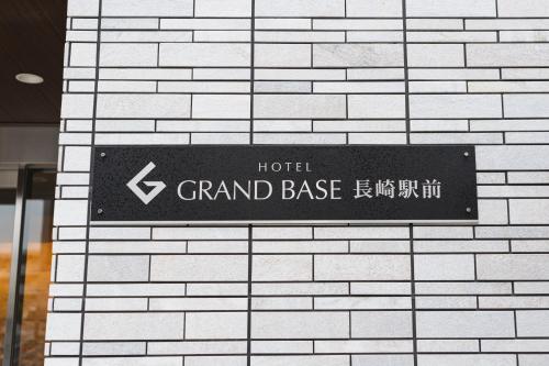 a sign for a hotel grand base on a brick wall at GRAND BASE Nagasaki Ekimae in Nagasaki