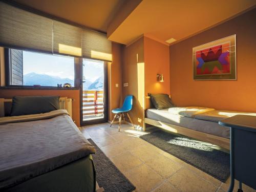 a bedroom with two beds and a desk and a chair at Tsar Bani Spa Resort in Gudauri