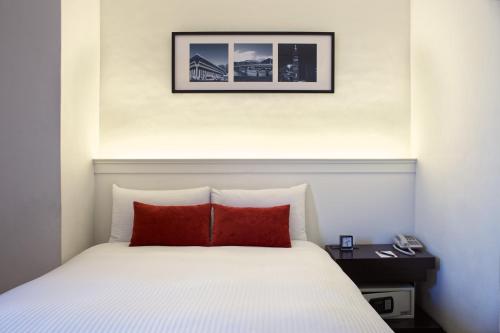 a bedroom with a bed and a lamp at 53 Hotel in Taichung