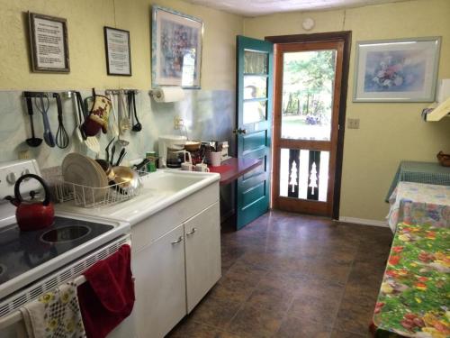 a kitchen with a sink and a stove top oven at Brookside Motel & Cabins in Lake George