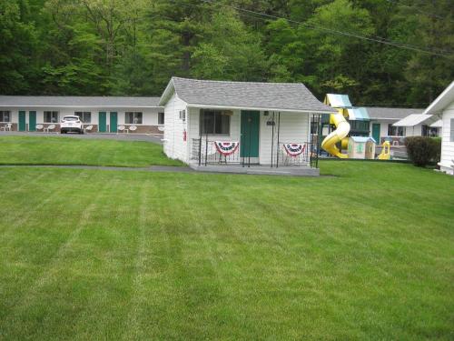 a house with a playground and a slide in a yard at Brookside Motel & Cabins in Lake George
