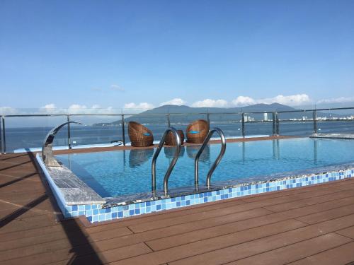 a swimming pool with two metal sculptures in the water at Gold Boutique Hotel Danang in Da Nang