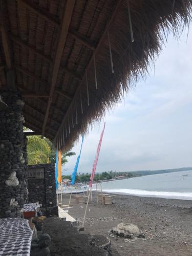 a beach with umbrellas and the ocean at Tasik Dumun Homestay and Waroeng in Amed