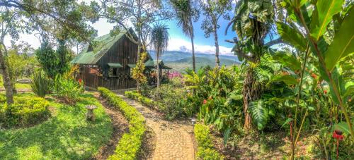 a path leading to a garden with a wooden building at Casa Campestre estilo Chalet Los Pirineos - Cerca a Cali in Cali