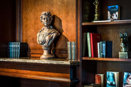 a bust of a woman on a shelf with books at Silverland Jolie Hotel in Ho Chi Minh City