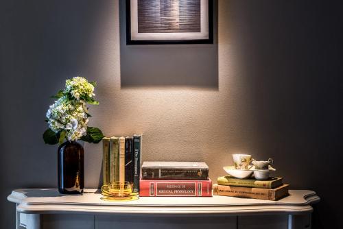 a table with books and a vase with flowers and books at Silverland Jolie Hotel in Ho Chi Minh City