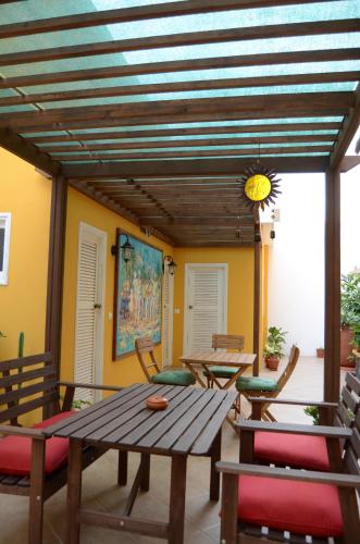 a patio with a wooden table and chairs at Kira's Boutique Hotel in Mindelo