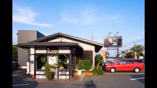 a red car parked in front of a building at Cocolie BEPPU in Beppu