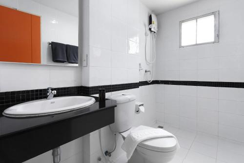 Baño blanco con aseo y lavamanos en D Varee Xpress Fullroom 77 Srinakarin en Samutprakarn