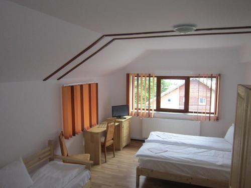 a room with two beds and a desk and a window at Pensiunea Casa Maria in Buşteni