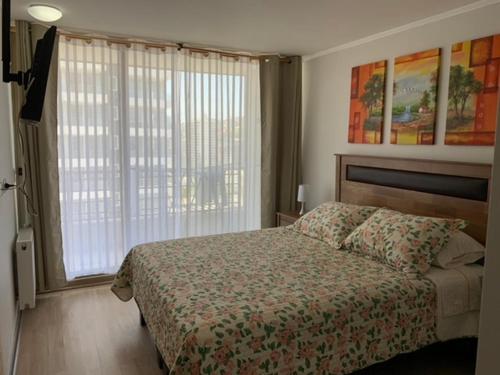 a bedroom with a bed and a large window at Departamento en el corazón de Viña del Mar in Viña del Mar