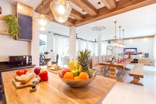a kitchen with a bowl of fruit on a table at Hi At Home Villa 5 in Nong Prue