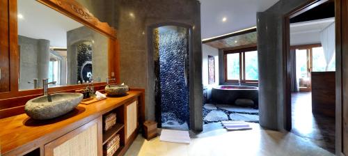 uma casa de banho com um lavatório e uma banheira em Kenran Resort Ubud By Soscomma em Ubud