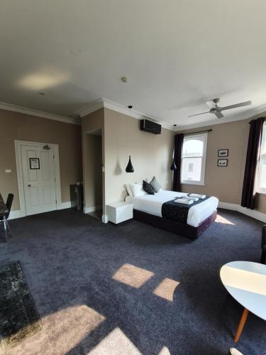 a large bedroom with a bed and a tv at Grand Hotel in Newcastle