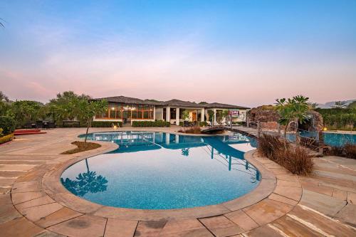 a swimming pool in a yard with a house at The Baagh Ananta Elite Ranthambore in Sawāi Mādhopur