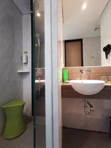 a bathroom with a sink and a shower with a mirror at MaxOne Platinum Hayam Wuruk in Jakarta