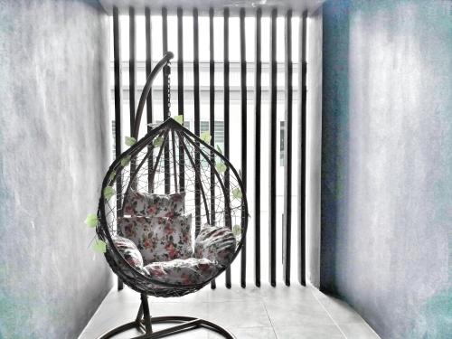 a hanging chair with a pillow in a room at 23Loft Kuching in Kuching