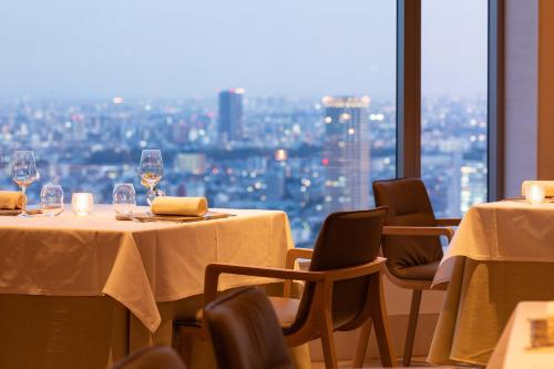 a restaurant with two tables and chairs and a window at Cerulean Tower Tokyu Hotel, A Pan Pacific Partner Hotel in Tokyo