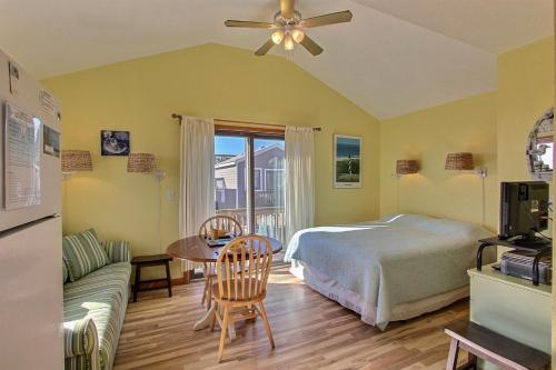 a bedroom with a bed and a table and a couch at NC 12 56821-40 Condo in Hatteras