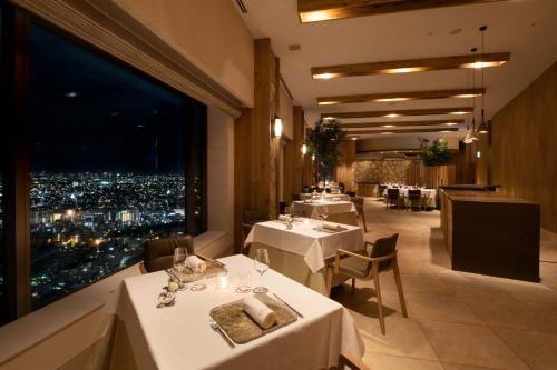 a restaurant with white tables and a view of the city at Cerulean Tower Tokyu Hotel, A Pan Pacific Partner Hotel in Tokyo
